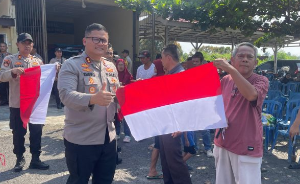 Polres OKU Bagikan Bendera Merah Putih ke Warga, Ajak sambut Antusias HUT RI ke80
