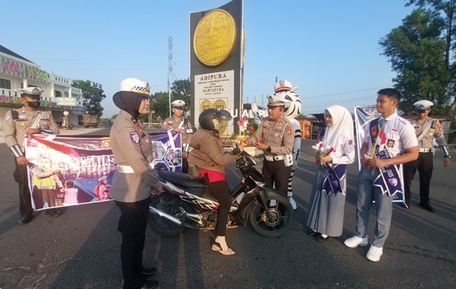 Hadirkan Badut Zebra, Bagikan Bendera ke Pengguna Jalan